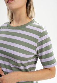 Leichte Baumwoll-T-Shirt mit horizontalen Streifen in Olivgrün und Lavendel. Rundhals und kurze Ärmel. Glatte Textur.