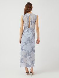 Robe imprimée florale bleu clair avec un dos en clé de voûte, design sans manches, texture transparente et une silhouette longue et fluide.