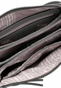 Grå zip-portmonnä med inre fack, som har en texturerad svart foder och ett ljusrosa tyg med tryckta textmönster.