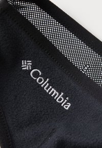 Mustavilla pehmeällä tekniikalla on kirjailtu "Columbia"-logo. Ylhäällä on verkkokohta, jossa on pieniä reikiä.