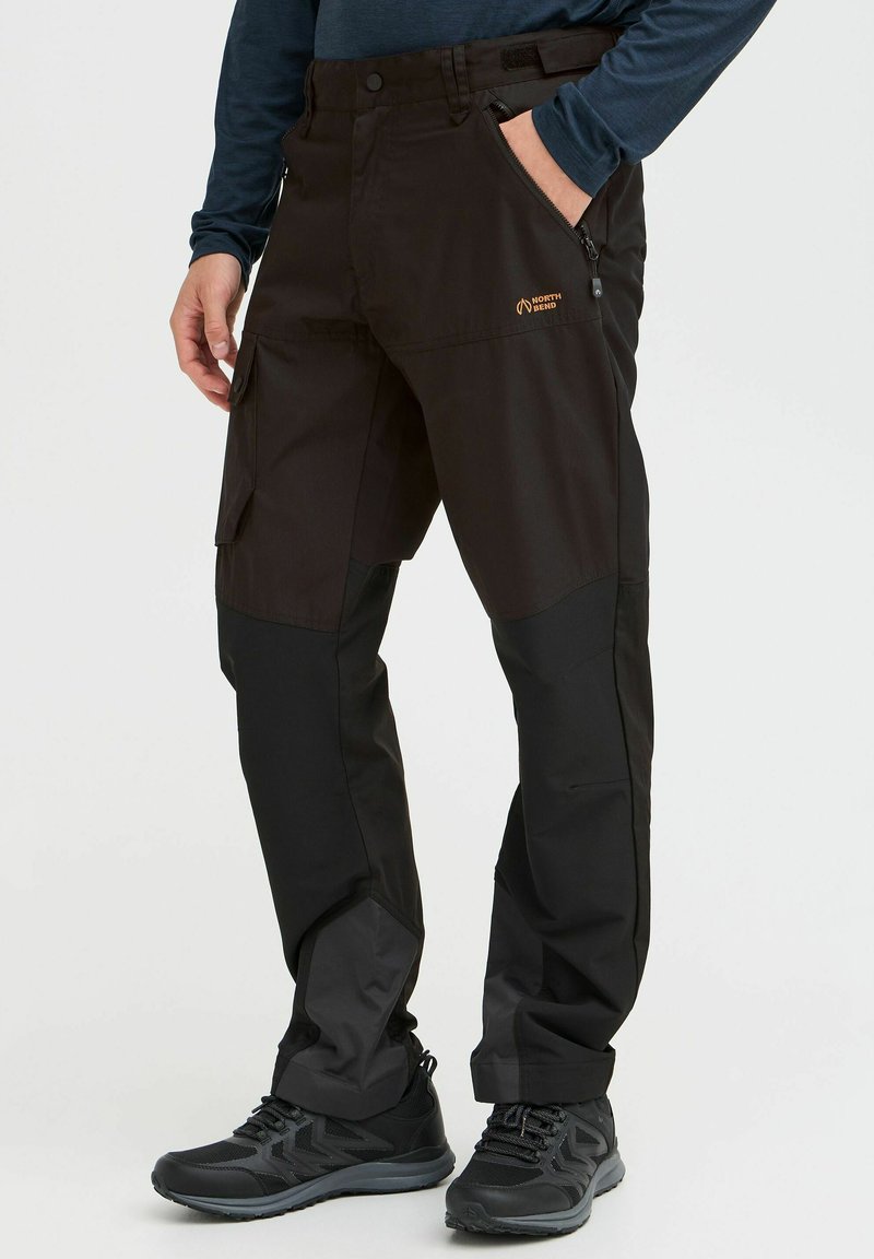 Schwarze Outdoor-Hosen aus robustem Material, mit einer Reißverschlusstasche, einem Design mit mehreren Taschen und verstärkten unteren Bereichen für zusätzliche Stärke.