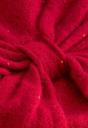 Roter Strickstoff mit einer weichen, flauschigen Textur, der ein gedrehtes Design aufweist und mit verstreuten Pailletten versehen ist, die ein lichtreflektierendes Element schaffen.