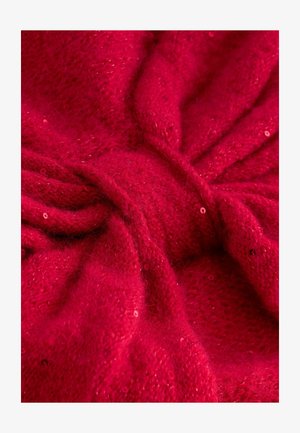 Roter Strickstoff mit einer weichen, flauschigen Textur, der ein gedrehtes Design aufweist und mit verstreuten Pailletten versehen ist, die ein lichtreflektierendes Element schaffen.