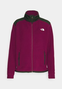 Fleecejacka i magenta med mörkgröna detaljer och hög krage. Har dragkedja fram och två sidofickor för förvaring.