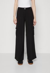 Black wide-leg cargo pants featuring a belted waist, two side pockets, and a light texture. Designed for a loose, relaxed fit.