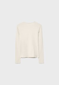 Long-sleeve shirt in cream, made from soft fabric. Features a round neckline, straight cut, and side slits at the hem for improved fit.