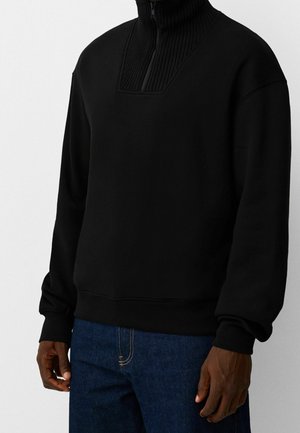 Schwarzer Sweatshirt mit einem hohen Rippkragen und Viertelreißverschluss, aus weichem Material gefertigt. Hat lange Ärmel und eine lockere Passform.