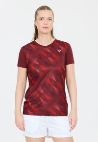 Rød og mørk maroon kortærmet sportsbluse med diamantmønster, lavet af et glat og let materiale; inkluderer en v-hals design.
