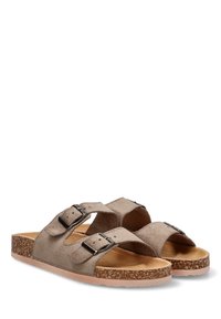 Sandalias de ante marrón con dos hebillas ajustables, una plantilla de corcho y una suela de goma texturizada. Diseño de punta abierta, estilo casual.