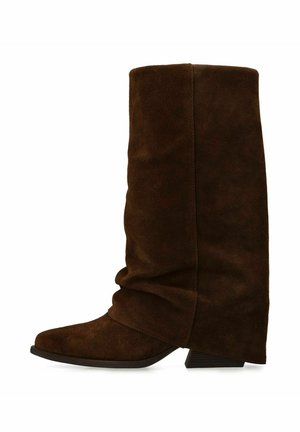 Brown suede knee-high boot with a slouch design, pointed toe, and a low block heel. Features smooth texture and minimal stitching accents.