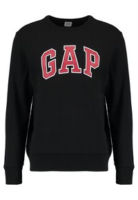 Sudadera negra de manga larga con grandes letras rojas y blancas en negrita "GAP" centradas en el pecho.