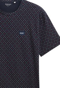 Short-sleeve navy T-shirt with a repeated red and white geometric pattern, featuring a small label on the chest. Soft fabric, regular fit.