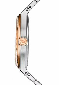 Sølv rustfrit stål ur med en rosegold bezel og krone. Har en tekstureret kant og en glat, poleret finish.