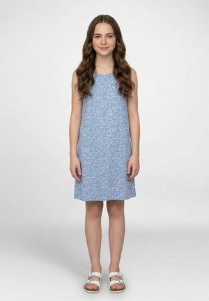 Lichtblauwe mouwloze jurk met een golvend patroon in de stof. Casual pasvorm, tot op de knie, gecombineerd met witte sandalen.