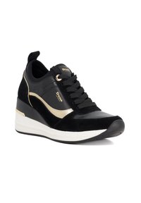 Black sneaker with a blend of suede and textured synthetic material. Features gold accents, lace-up design, and a white midsole with a wedge heel.