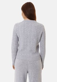 Maglione grigio lavorato a maglia con scollo rotondo, orlo a coste e maniche lunghe con un motivo testurizzato. Tessuto morbido e lavorato a maglia.