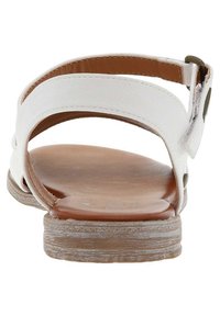 Weiße Ledersandale mit zwei breiten Riemen, einer braunen Innensohle und einer hellbraunen strukturierten Außensohle. Sie verfügt über eine Metall-Schnalle zur Anpassung.