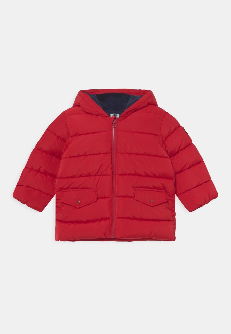 Doudoune rouge avec capuche, dotée d'une fermeture éclair à l'avant, de deux poches avant et d'une texture matelassée. Doublée d'un intérieur bleu marine.