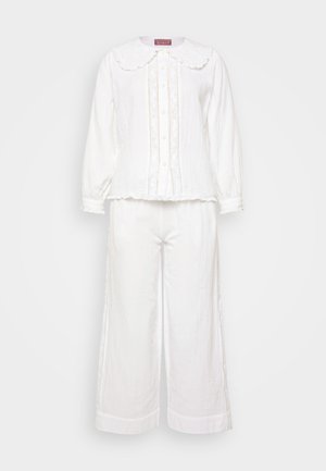 White two-piece outfit featuring a button-up top with a large scalloped collar and decorative stitching, paired with wide-leg pants.