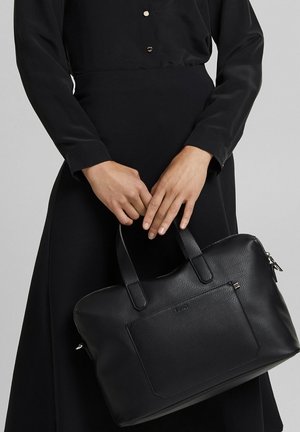 Zwarte lederen handtas met dubbele handvatten, rechthoekige vorm, getextureerd oppervlak en een voorvak. Afgesloten met een ritssluiting aan de bovenkant.