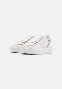 Witte sneakers met een gestructureerd oppervlak, contrasterende beige accenten, platte veters en een platte zool met subtiele stiksels.