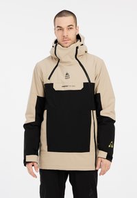 Beige en zwarte waterdichte jas met verstelbare capuchon, voorzak, logodetails en contrasterend kleurblokontwerp. Gladde textuur.