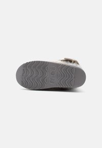 Apakšējā apavu daļa ar teksturētu pelēku ārzoli, uz kuras ir viļņota raksta. Zīmola logotips "mau" ir iespiests sānos.