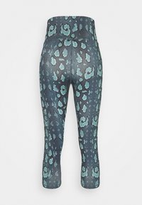 Leggings a vita alta con un fondo scuro, caratterizzate da una fantasia animalier turchese; il tessuto appare elastico e con una texture liscia.