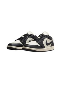Svartvita lädersneakers med snörningsdesign, krämiga detaljer, rund tå och en texturerad gummisula med en signaturlogotyp.