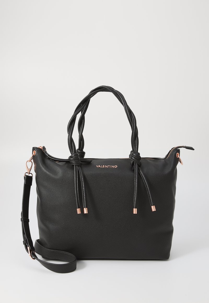 Black leather tote bag with knotted top handles, rose gold accents, adjustable shoulder strap, and textured finish. Logo on front.