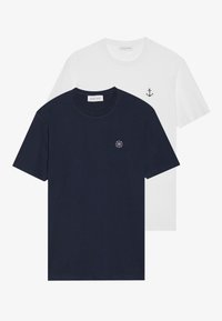 To t-shirts: en marineblå med et cirkulært logo, den anden hvid med et lille ankerdesign. Lavet af bomuld, kortærmede.