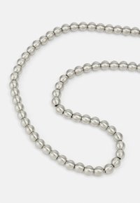 Metallic silver necklace featuring smooth, rounded beads with a matte finish, strung in a continuous loop.