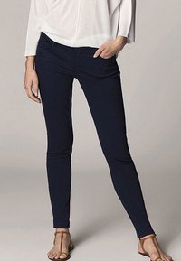 Navyblauwe skinny jeans van rekbare stof met een gladde textuur. Voorzien van een voorzak en een getailleerde pasvorm.
