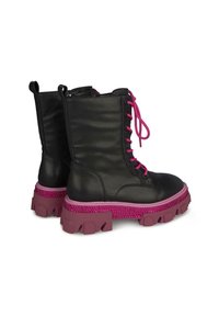 Botas de combate de cuero negro con suelas gruesas rosas, detalles en pedrería rosa y cordones rosas, mostradas desde los ángulos trasero y lateral.
