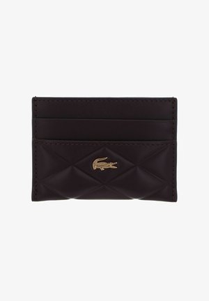 Porte-cartes en cuir marron foncé avec face avant matelassée, trois emplacements pour cartes et logo crocodile doré centré sur le devant.