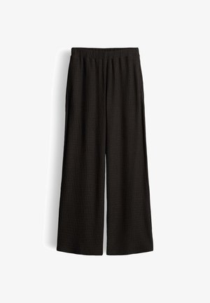 Pantaloni neri a gamba larga con cintura elastica e tessuto finemente strutturato, mostrati distesi su sfondo bianco.