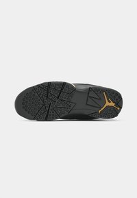 Mustade spordijalatsite välistald, millel on tekstuuriga kummitald ringjate haardepindade ja nurkade mustritega; kuldne Jumpman logo aktsent.