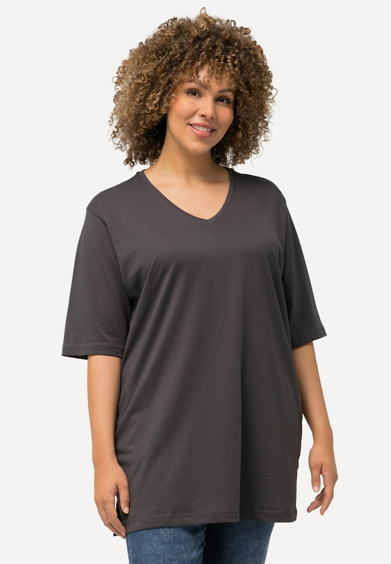 Kohlegraues V-Ausschnitt-T-Shirt mit kurzen Ärmeln, lockerer Passform, glatter Textur und geradem Saum, kombiniert mit blauen Jeans.
