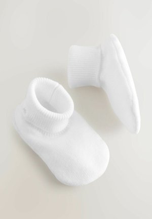 Valkoiset nilkkasukat, joissa on ribbikuvioitu resori ja pehmeä pinta, pyöreä kärki ja minimalistinen muotoilu.