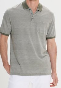Polo gris con cuello verde, que presenta un patrón texturizado de rayas horizontales y una tapeta de tres botones. Mangas cortas.