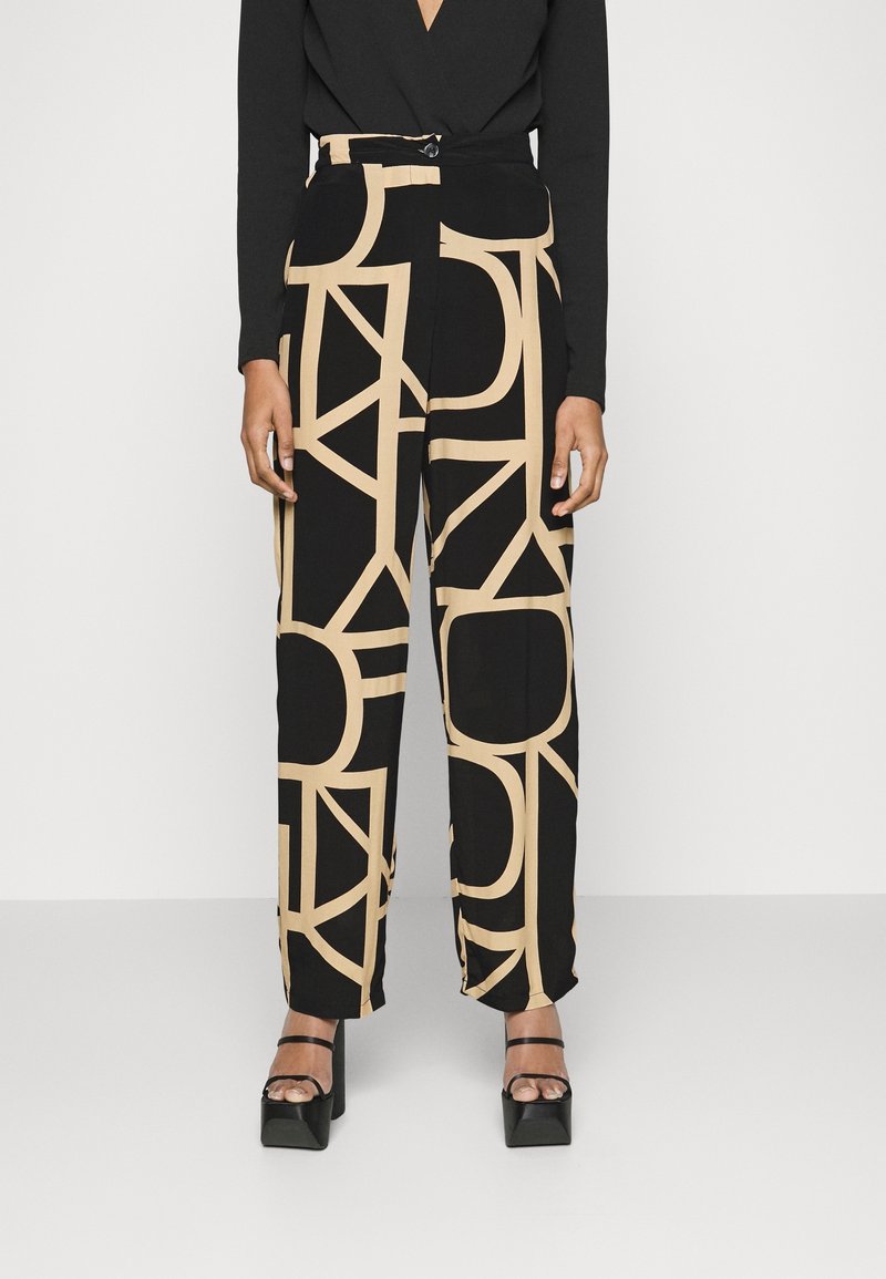 Czarne spodnie z dużymi beżowymi abstrakcyjnymi wzorami geometrycznymi, wysoki stan, szerokie nogawki oraz zapięcie na guzik w talii.
