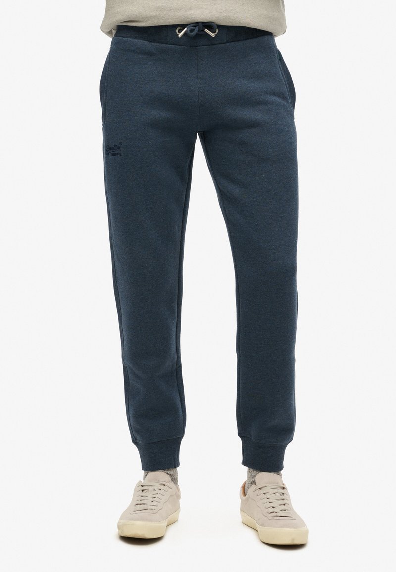 Marineblauwe joggingbroek van zacht materiaal, met een tailleband met trekkoord, zijzakken en geribde cuffs voor een comfortabele pasvorm.