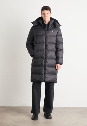 Black puffer coat with quilted design, high collar, full zip closure, and side pockets. Lightweight, insulated material offers warmth.