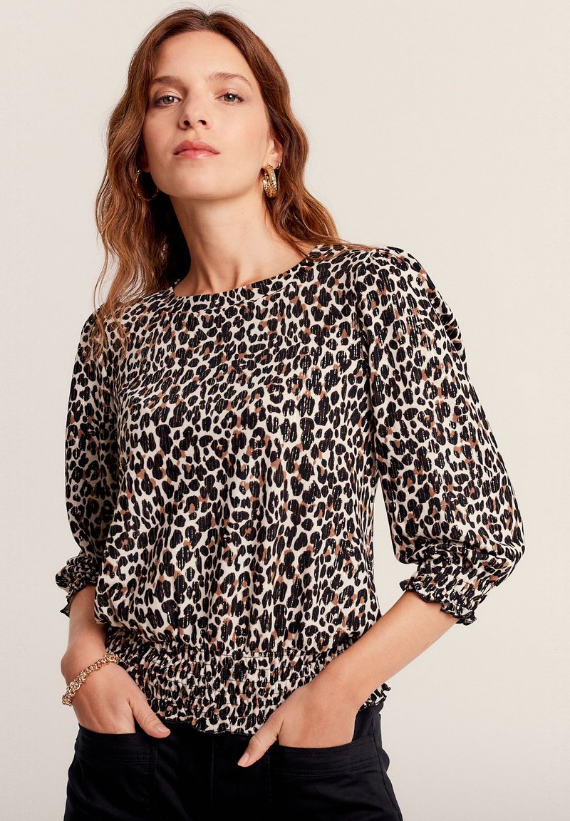 Blusa a fantasia leopardata in tessuto leggero, con scollatura rotonda, polsini arricciati e orlo elasticizzato per una vestibilità comoda.