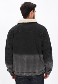 Czarna dżinsowa kurtka z kontrastowym białym kołnierzem z sztucznego owczej skóry, z gradientowym szarym wybarwieniem, długimi rękawami i luźnym krojem.