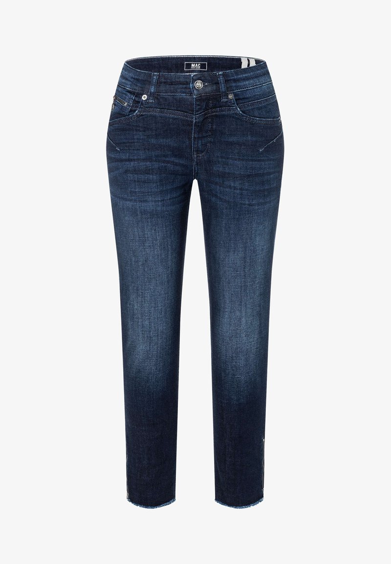 Jeans de mezclilla azul oscuro con un corte ajustado, estilo de cinco bolsillos, cierre de cremallera y un dobladillo sin acabar en los tobillos. Acentos cosidos visibles.