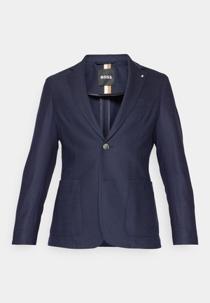 Marineblaues Blazer mit einem einzigen Knopfverschluss, zwei frontalen Taschen und einem Reverskragen. Strukturierter Stoff mit slim fit Design.