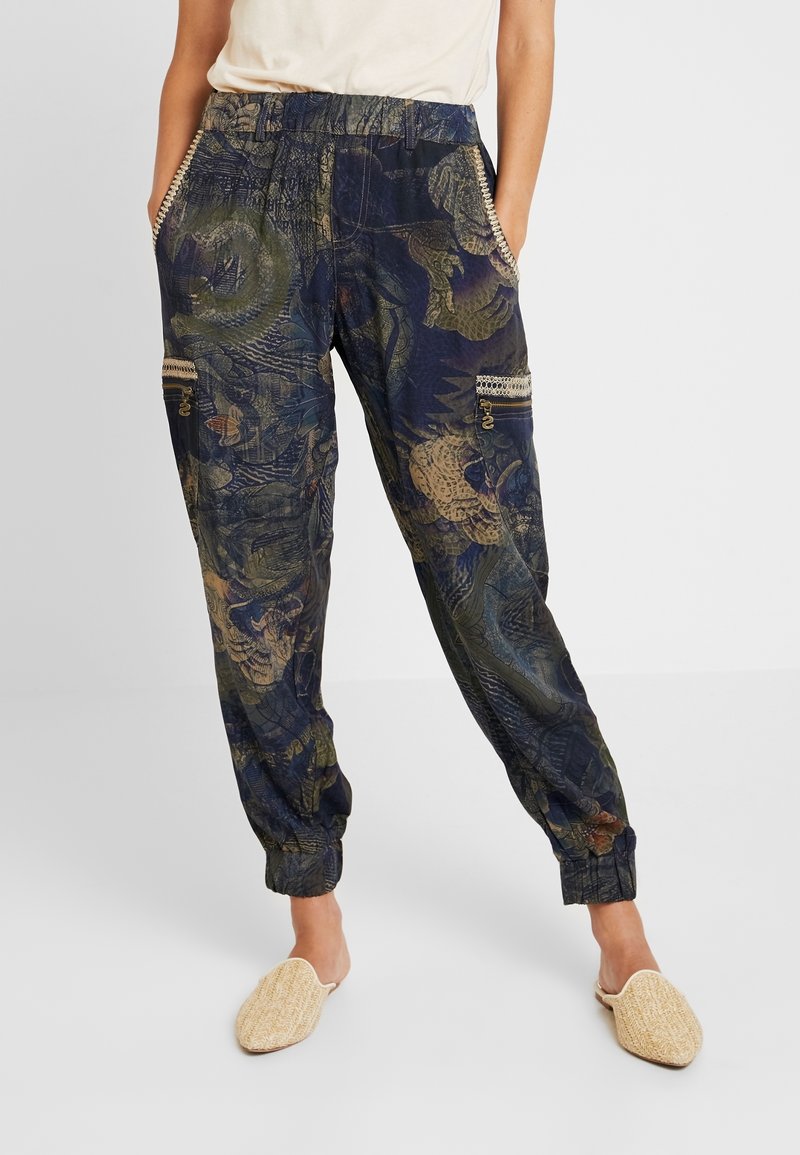 Pantalon de jogging bleu marine imprimé avec un motif floral et un dragon, doté de poches latérales, d'une taille élastique et de poignets. Tissu léger.