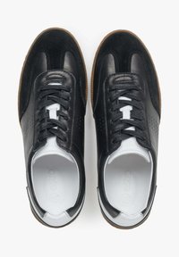 Zwarte leren sneakers met een suede accent, ronde neus, vetersluiting aan de voorkant, witte tong, geperforeerde details en een gestructureerde bruine rubberen zool.