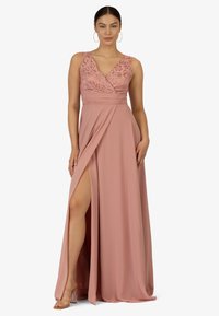 Lungo vestito rosa con scollatura a V, corpino in pizzo e spacco laterale. Realizzato in tessuto morbido con pieghe in vita e una gonna fluida.